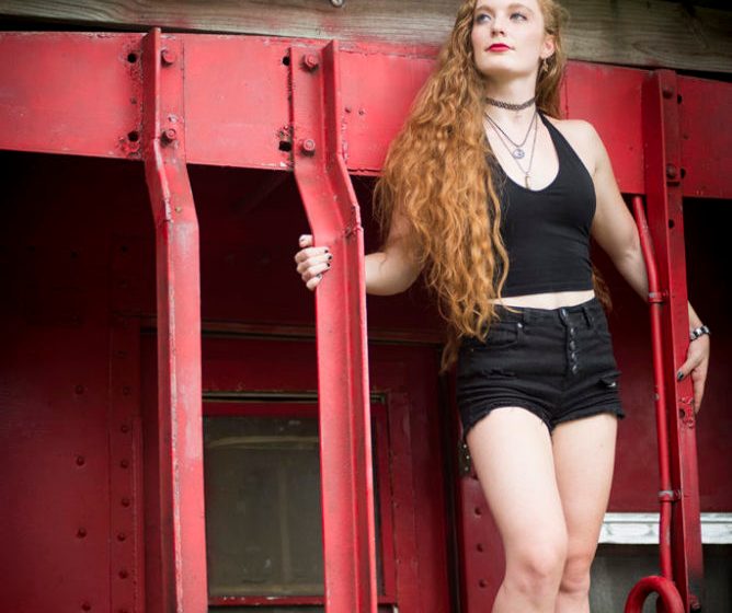 Photo of Nicole Korolevich in black posing on a caboose