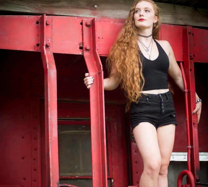 Photo of Nicole Korolevich in black posing on a caboose