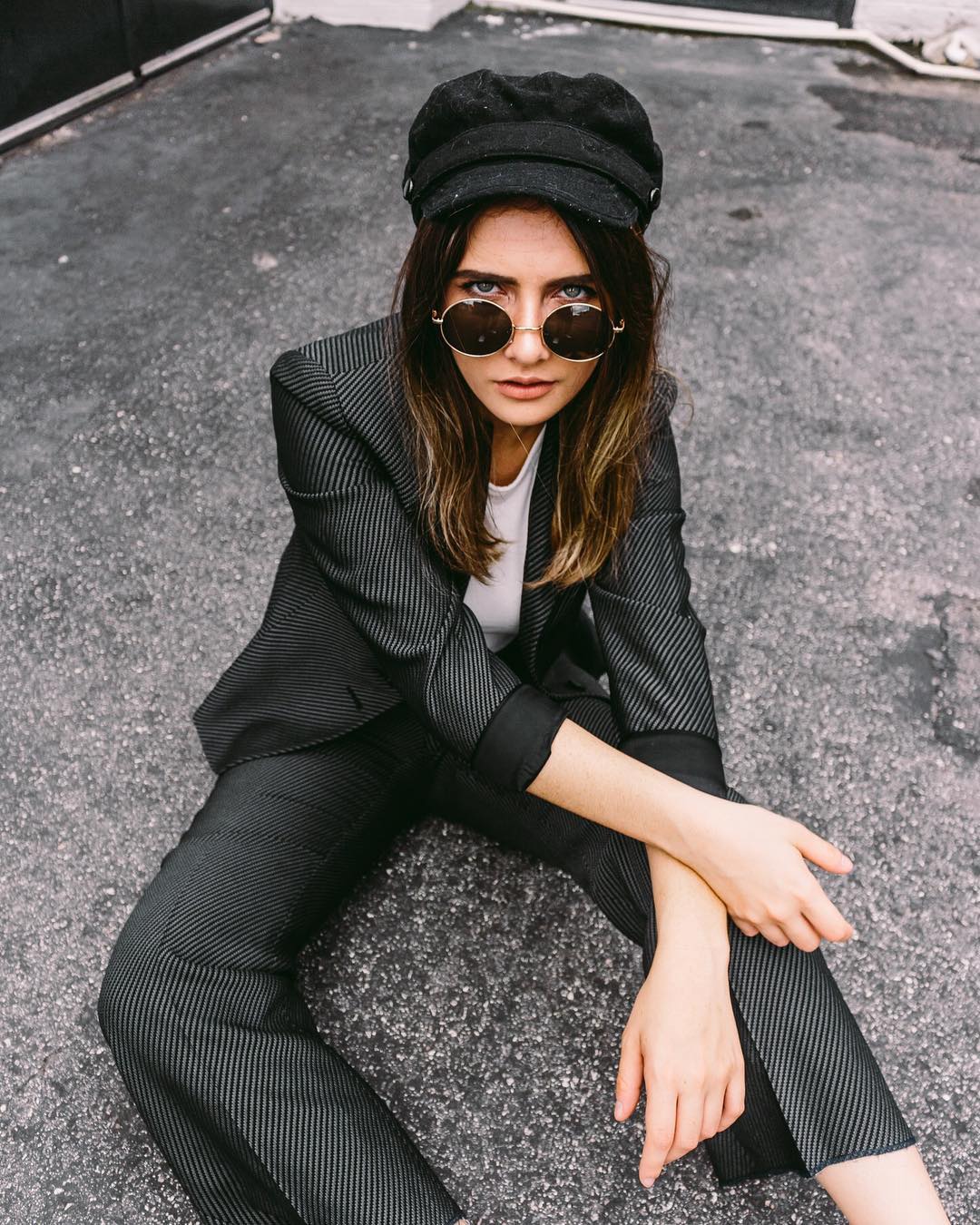 power suit, sunglasses and fisherman's cap 