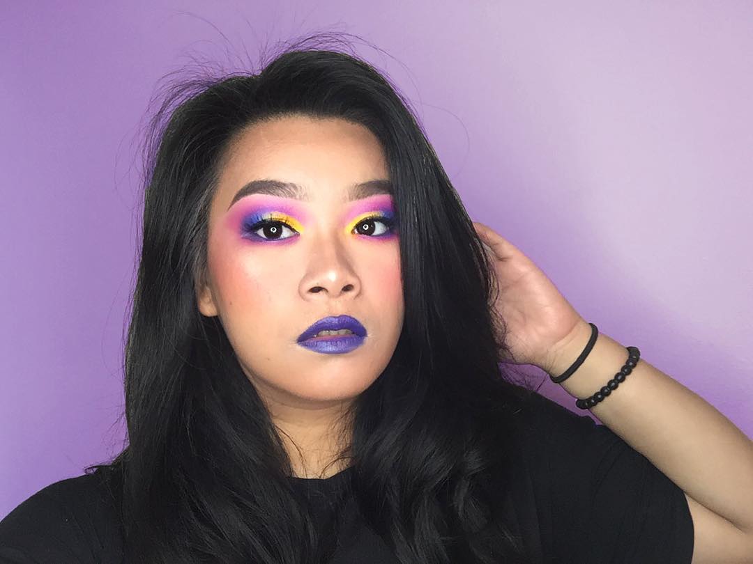 neon pink, purple, and yellow eye look with purple lipstick