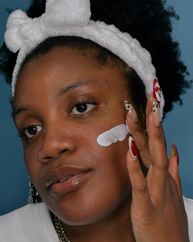 Woman putting CeraVe cream on her face